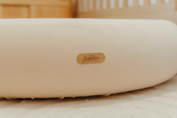 Close-up of Jupiduu soft pouf in neutral kids’ room – premium floor cushion with stitched logo detail for toddler play and seating