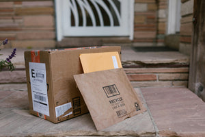Cardboard boxes and a mailer envelope on a doorstep, representing home delivery of online orders.