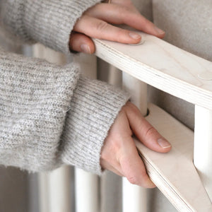 Hands adjusting the wooden frame of a FitWood product, highlighting the smooth, well-crafted birch design that is simple to maintain and built for long-lasting durability.