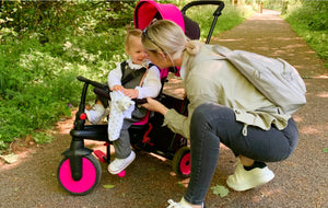 Mother engaging with child in smarTrike stroller trike - bright pink canopy and comfortable design for outdoor adventures by Little Gliders