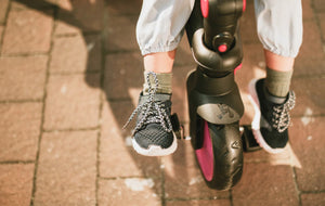Close-up of child's feet on smarTrike footrest - sturdy design and secure ride with Little Gliders trike