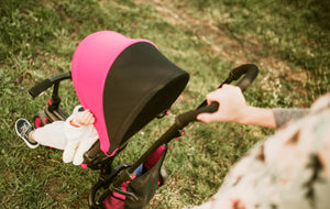 Parent pushing smarTrike stroller with bright pink canopy - outdoor ride with sun protection and easy steering by Little Gliders
