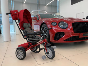 Bentley 6-in-1 Trike in Dragon Red parked beside a matching red Bentley car, highlighting the trike's luxury design and replica wheels.