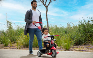 Father pushing his child on a smarTrike tricycle - ideal for outdoor family adventures and safe rides by Little Gliders