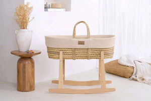 Natural woven Moses basket with cream liner and wooden rocking stand – minimalist newborn baby bassinet in neutral nursery setting