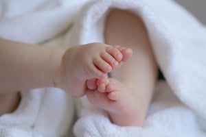 Close-up of baby feet wrapped in a soft white towel – symbolising comfort, care, and sustainable baby essentials.