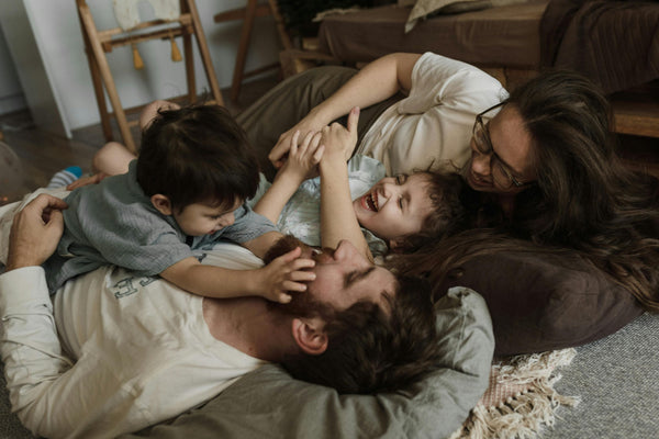 Happy family relaxing and laughing together at home – symbolising trust, bonding, and joyful parenting moments