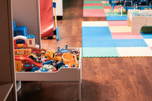 Indoor playroom corner with toy storage and colourful foam mats, showing a tidy, space-smart setup for small-space active play