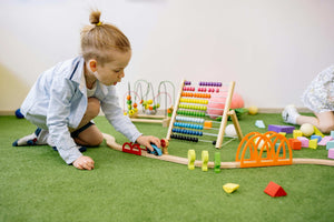 Young child playing on indoor climbing and sensory toys from Little Gliders, designed to support focus, emotional regulation, and resilience through movement-based play