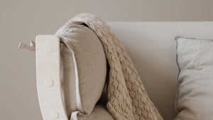 Close-up of a beige cushion on a FitWood rocking chair, showing the smooth wooden frame and minimalist Nordic design.