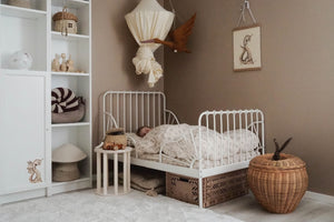 A peaceful child sleeping in a Scandinavian-inspired nursery featuring a minimalist bed, wooden toys, and wicker storage, promoting a cosy and natural bedroom design for toddlers. Fitwood Luoto Stool Little Gliders