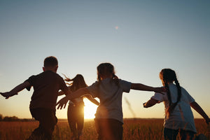 Group of children running through a field at sunset, enjoying outdoor playtime_LITTLE GLIDERS Retail Finance Payl8r Application Success