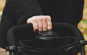 Close-up of parent holding the smarTrike stroller handle with integrated cup holder - designed for comfort and convenience by Little Gliders