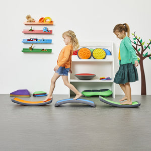 Two young children balancing on curved Gonge play boards, building coordination and motor skills.