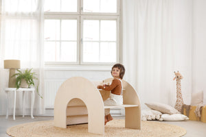 A child sitting at the multi-functional FitWood table and bench, designed for kids, made from eco-friendly birch wood with a minimalist, modern aesthetic.