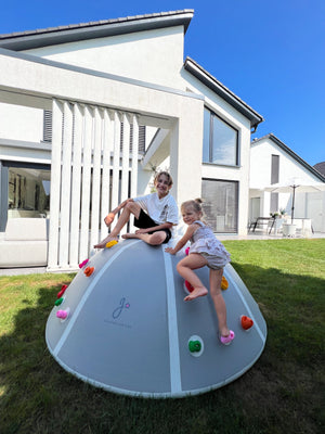 Two children enjoying outdoor play on the Jupiduu Climb & Jump Dome, perfect for building strength, coordination, and imaginative fun – available at Little Gliders.