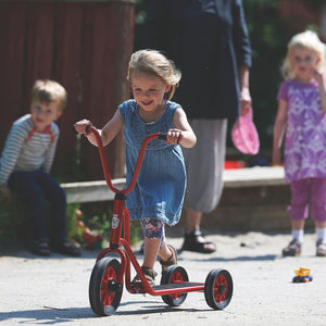 A young girl enjoying outdoor fun on a red Winther tricycle, inspiring active play and exploration – available at Little Gliders.